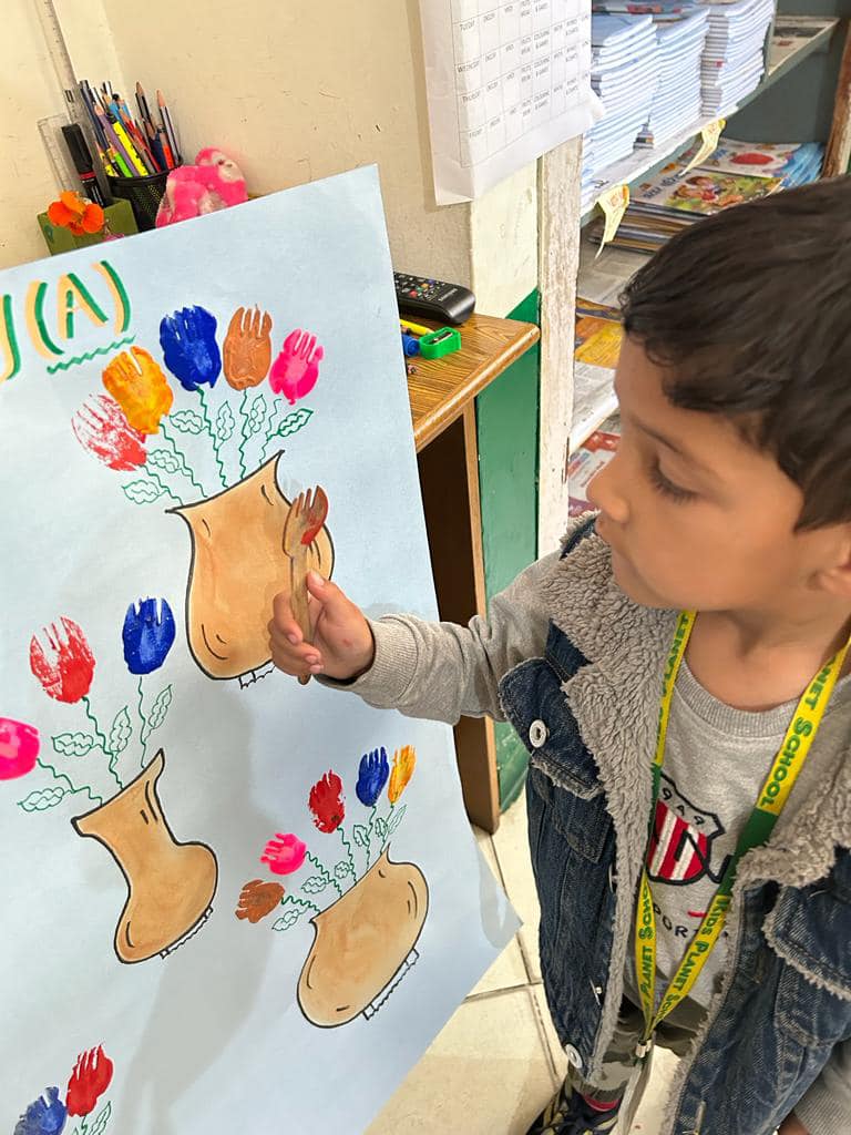 Young students creating colorful handprint art