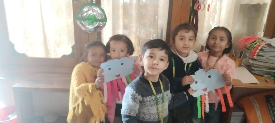 Little ones holding up their colorful paper craft creations