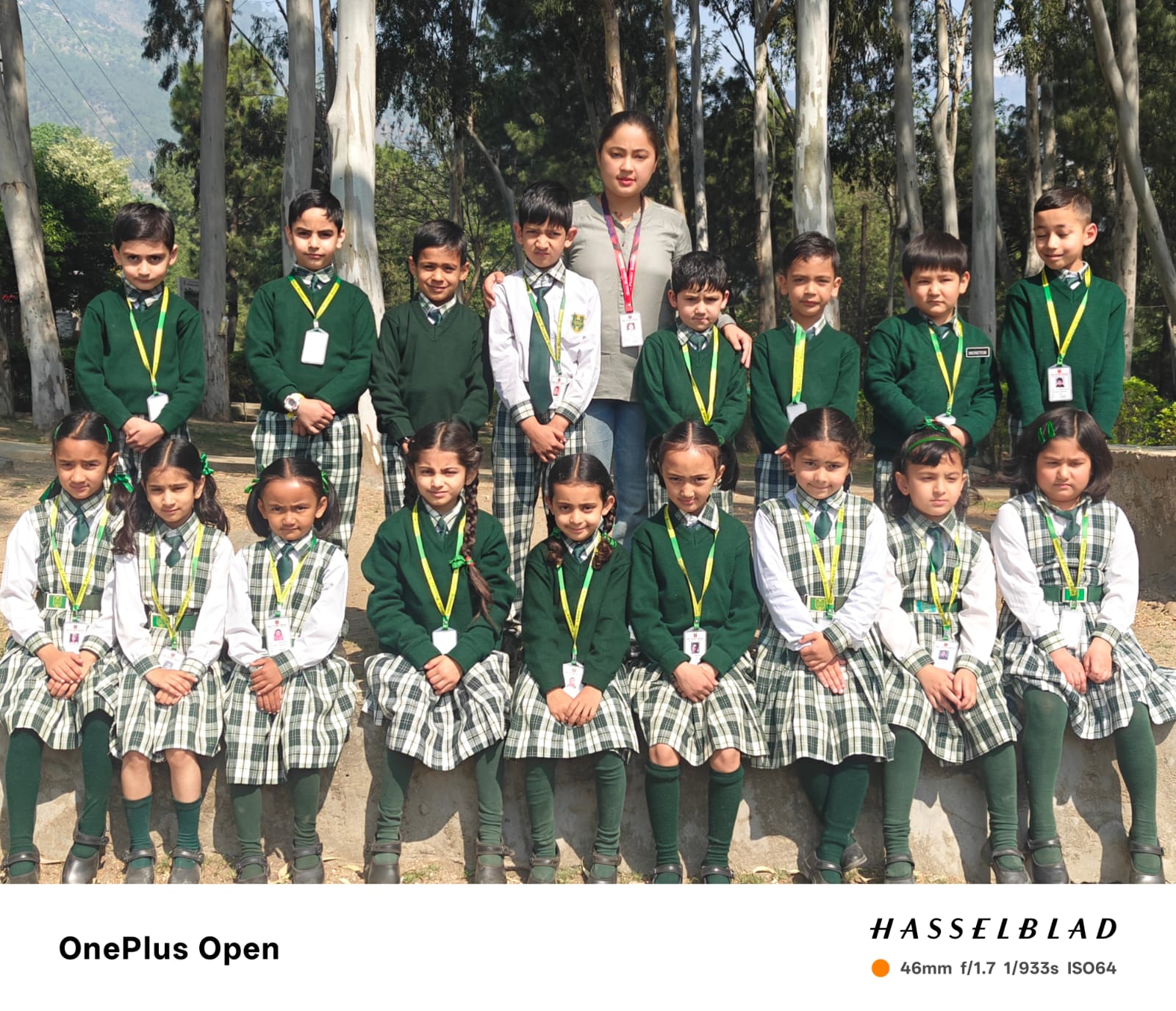 Class 1 group photo — 19 students in green uniforms with their class teacher
