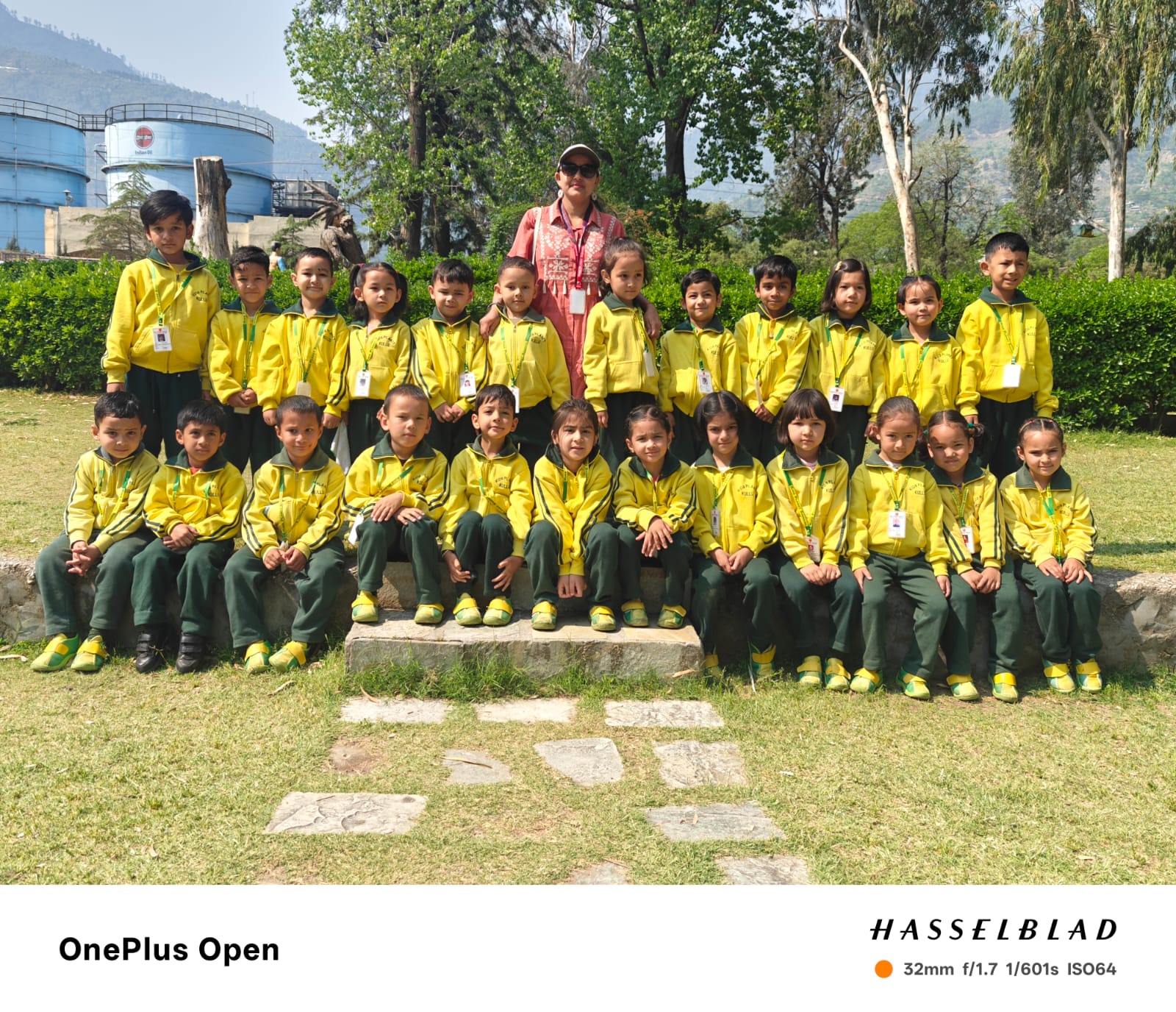 LKG class group photo — 30 students in yellow uniforms outdoors