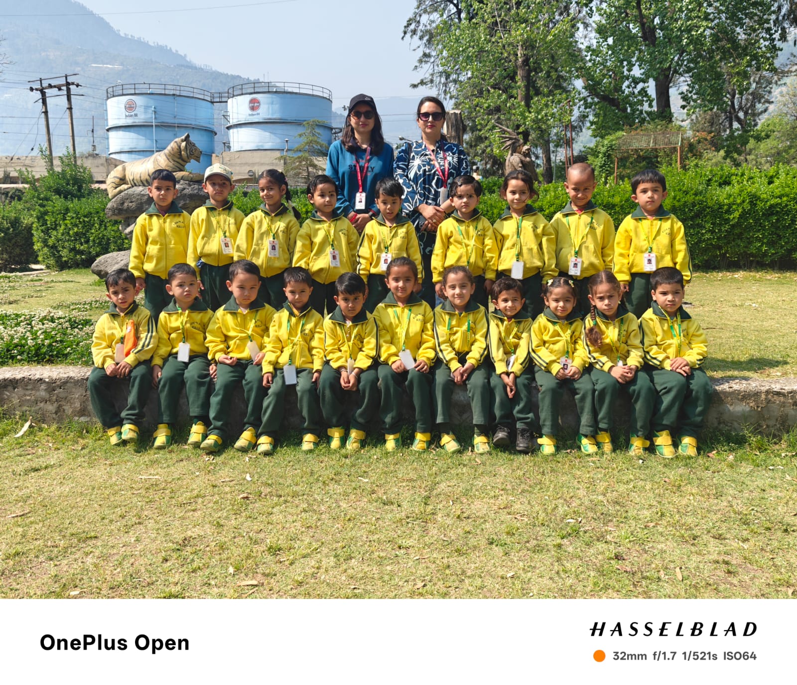Nursery class group photo — 26 bright students in yellow uniforms with their teacher