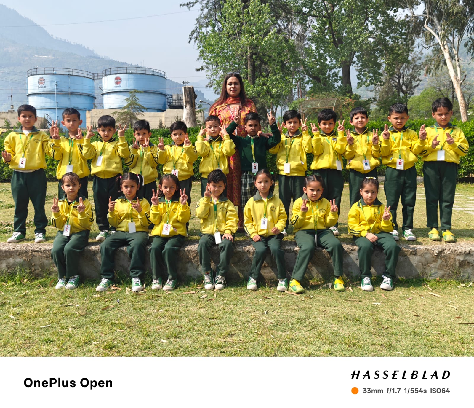 UKG class group photo — 22 students in yellow uniforms at the park
