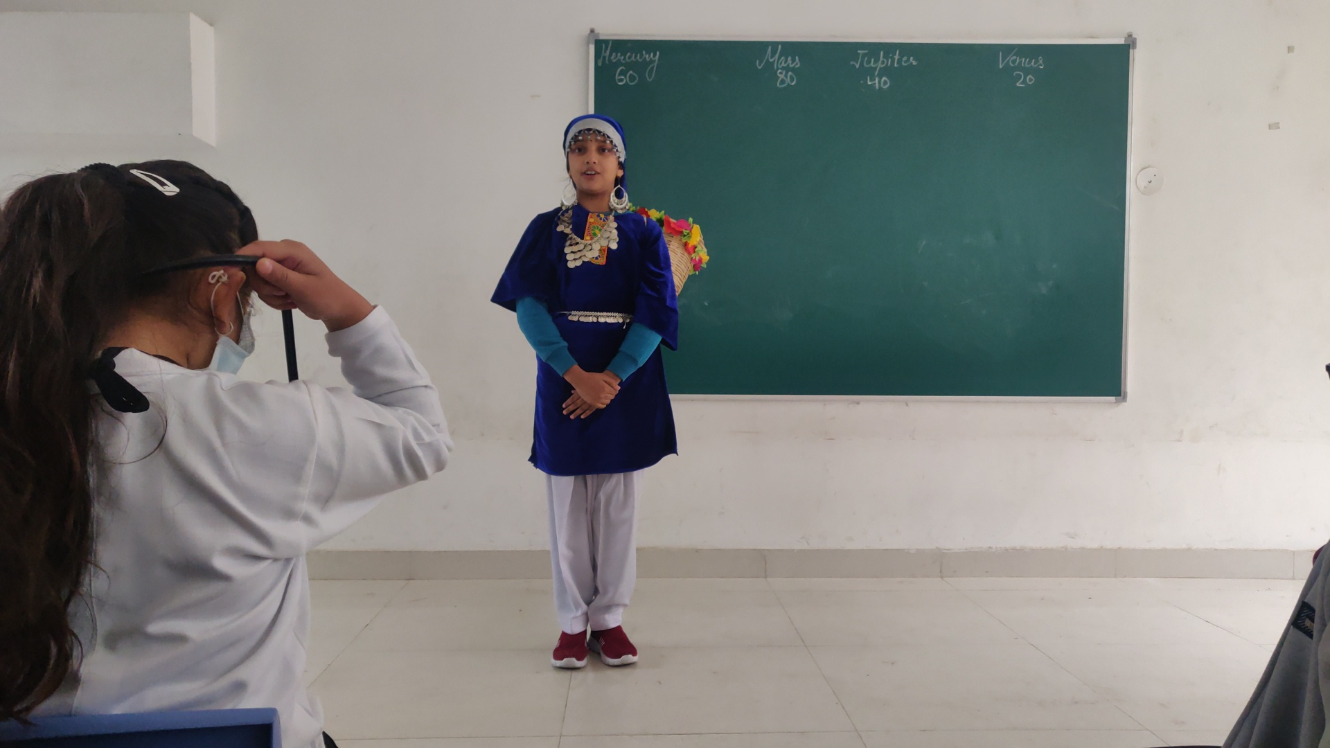 Student performing in traditional outfit during cultural program
