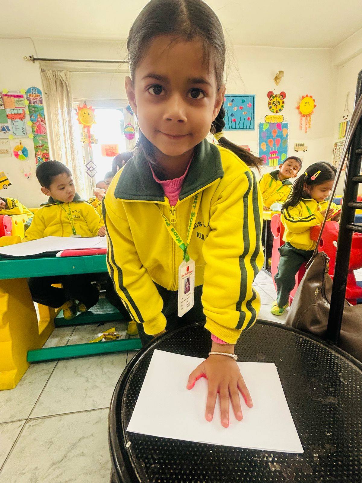 Portrait of a student in yellow Kids Planet jacket in a decorated classroom