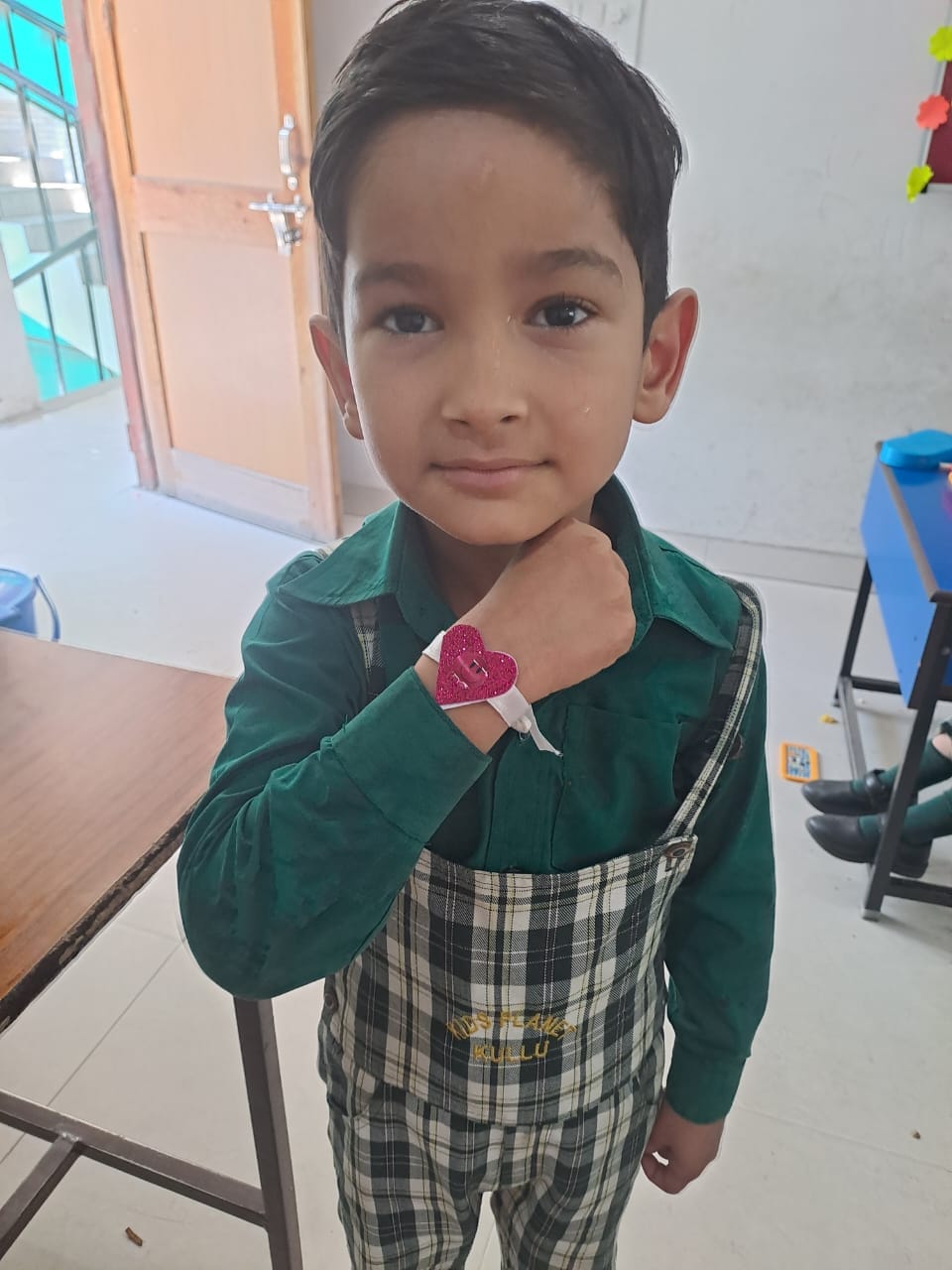A young student proudly showing a handmade heart craft