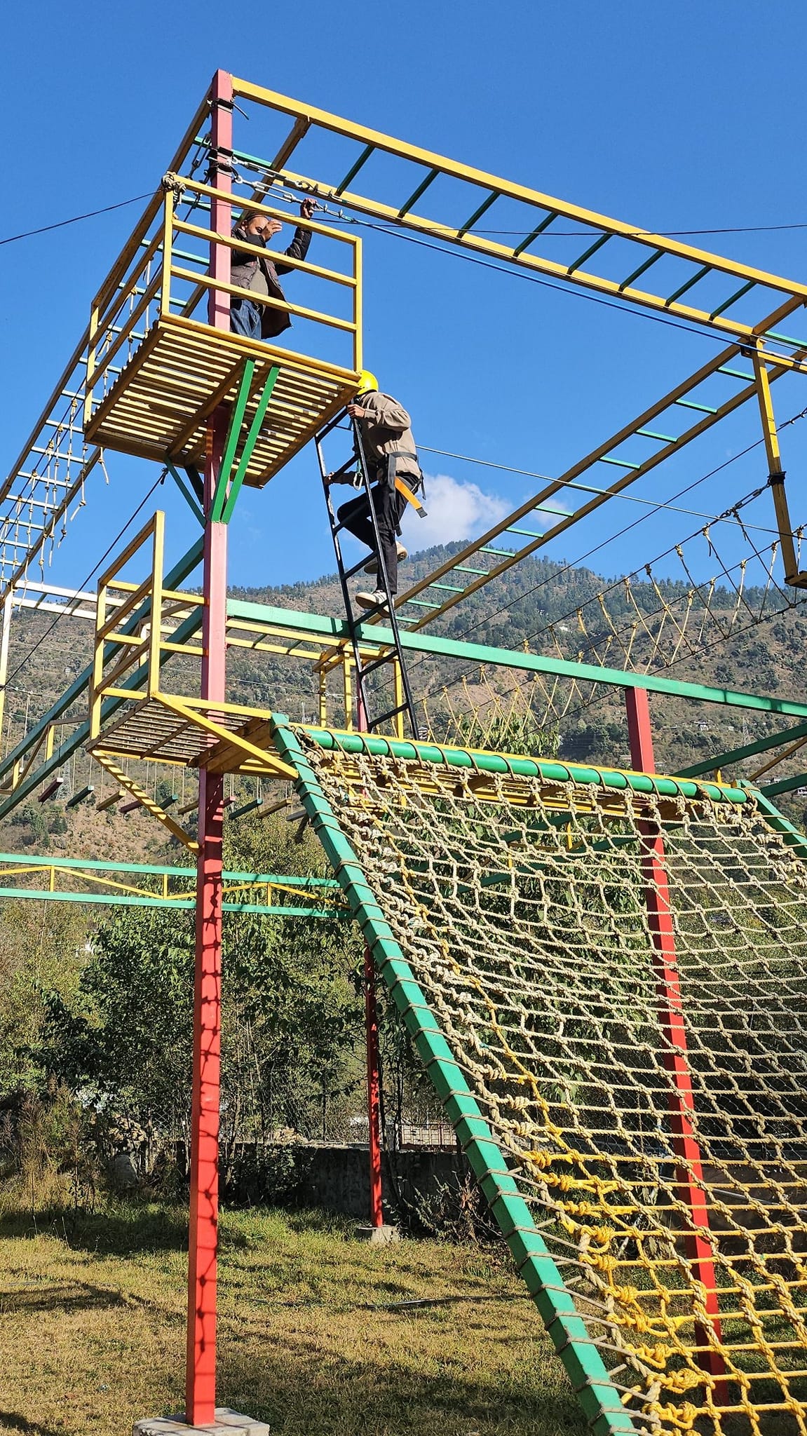 Adventure activities — climbing structure with mountain backdrop